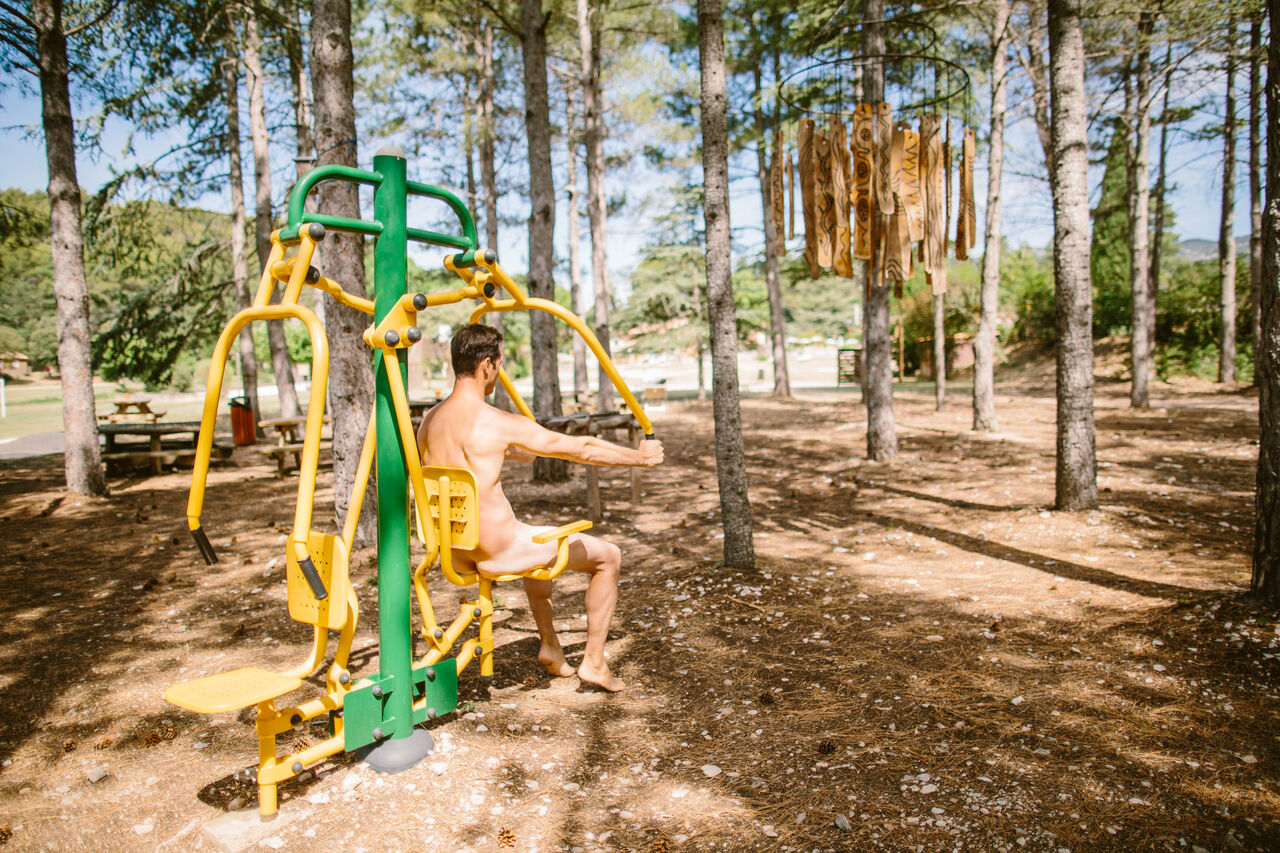 Naturistische man gebruikt outdoor fitnessapparaat op camping LIBRANOO Naturiste Belezy in B�doin (84).