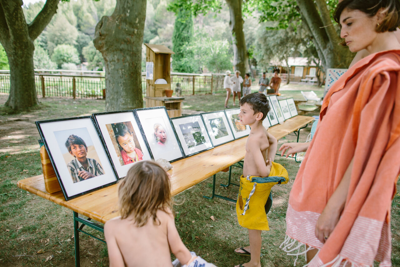 Kinderen bekijken fototentoonstelling buiten op camping LIBRANOO Naturiste Belezy in B�doin (84).