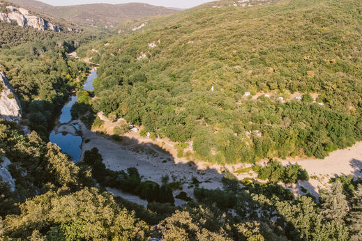 Luchtfoto rivier, groene vallei op camping LIBRANOO Naturiste Sabliere in Barjac (30).