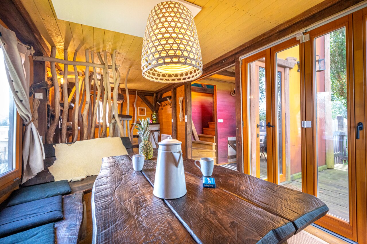 Rustiek interieur Boomhut, houten tafel, op camping CAPFUN Donjon de Lars: Boomhutten in Courseulles-sur-Mer (14).