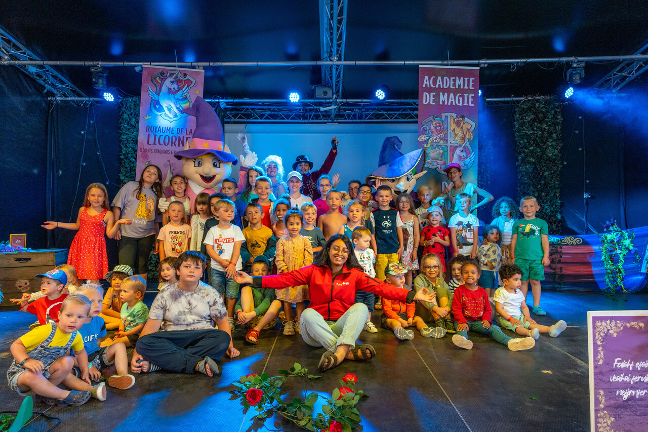Kinderen en animatoren op podium voor show op camping CAPFUN Donjon de Lars: Boomhutten in Courseulles-sur-Mer (14).