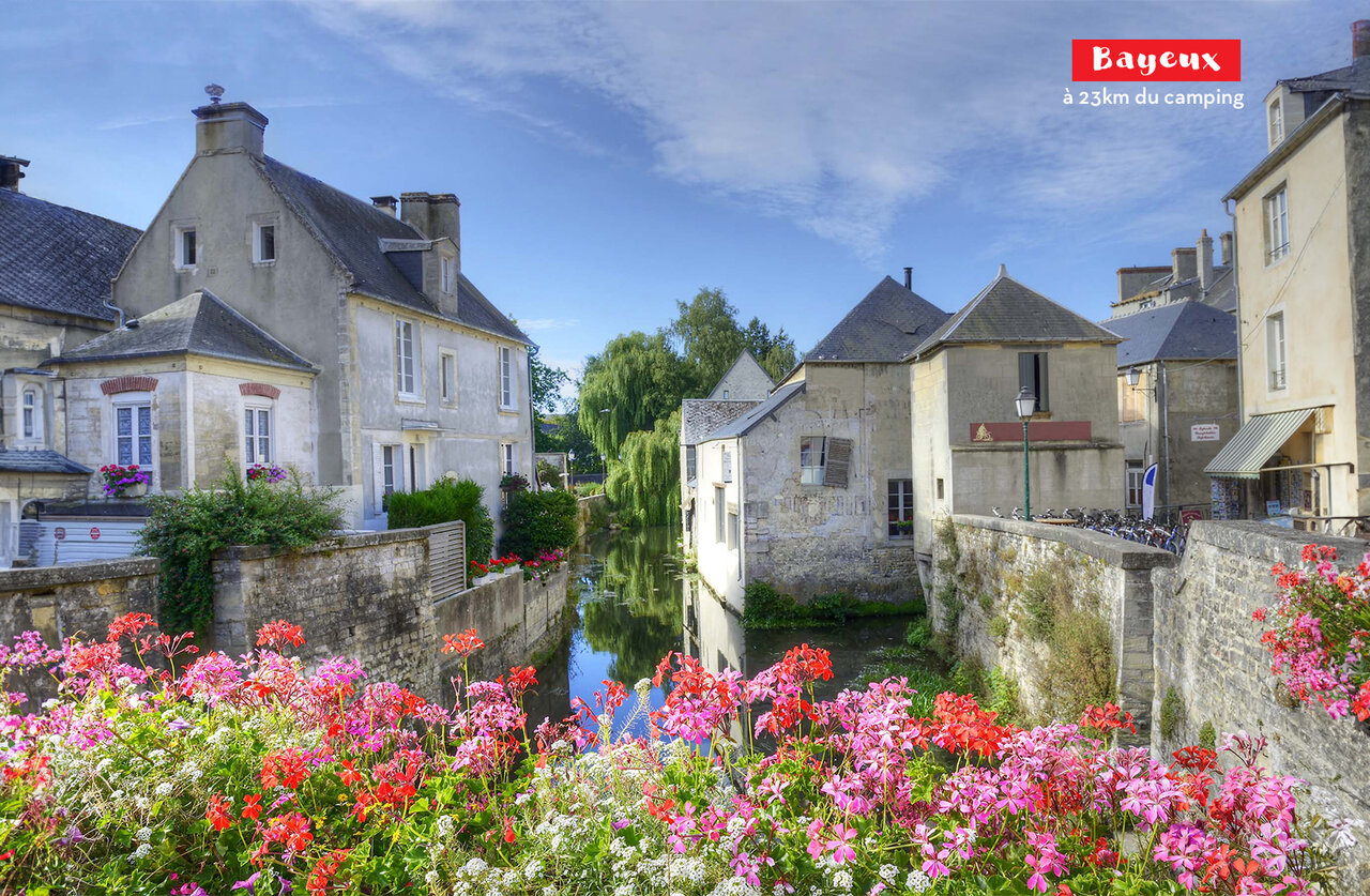 Historische stad Bayeux, middeleeuwse huizen en bloemrijke rivier, te bezoeken nabij de camping.