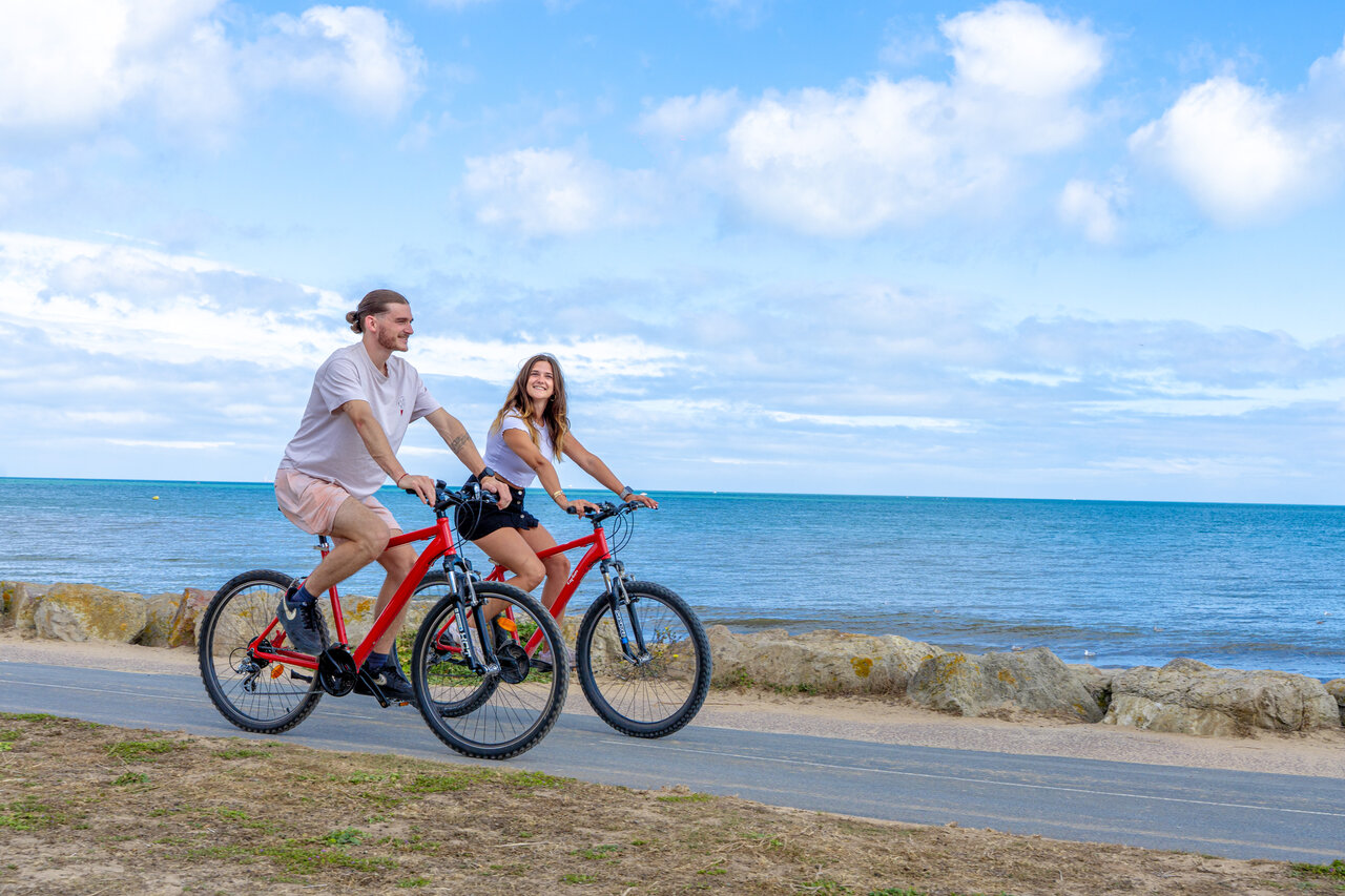 Koppel fietst langs de kust, CAPFUN Donjon de Lars, Courseulles-sur-Mer.