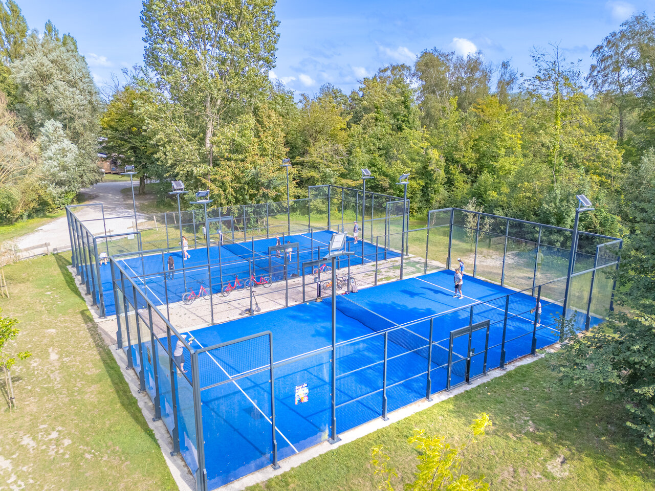 Blauwe outdoor padelbanen met spelers bij CAPFUN Dune Fleurie, Quend Plage (80).
