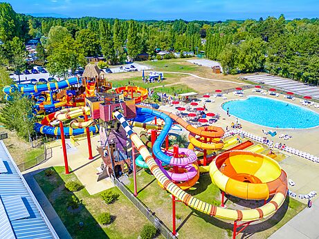 Kleurrijke waterglijbanen en groot buitenzwembad vanuit de lucht op camping CAPFUN Dune Fleurie in Quend Plage (80).