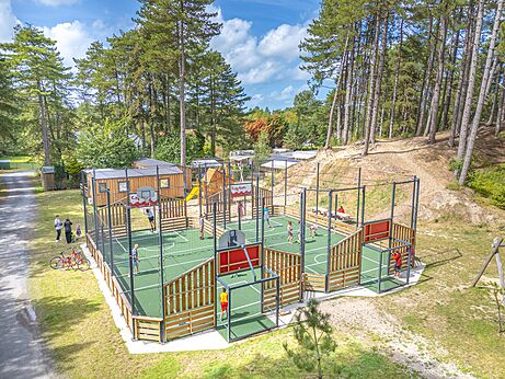 Multisportterrein met kinderen die basketbal en voetbal spelen op camping CAPFUN Dune Fleurie in Quend Plage (80).