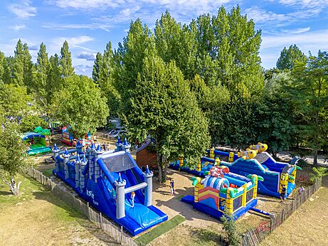 Grote opblaasbare speeltoestellen en glijbanen voor kinderen op camping CAPFUN Dune Fleurie.