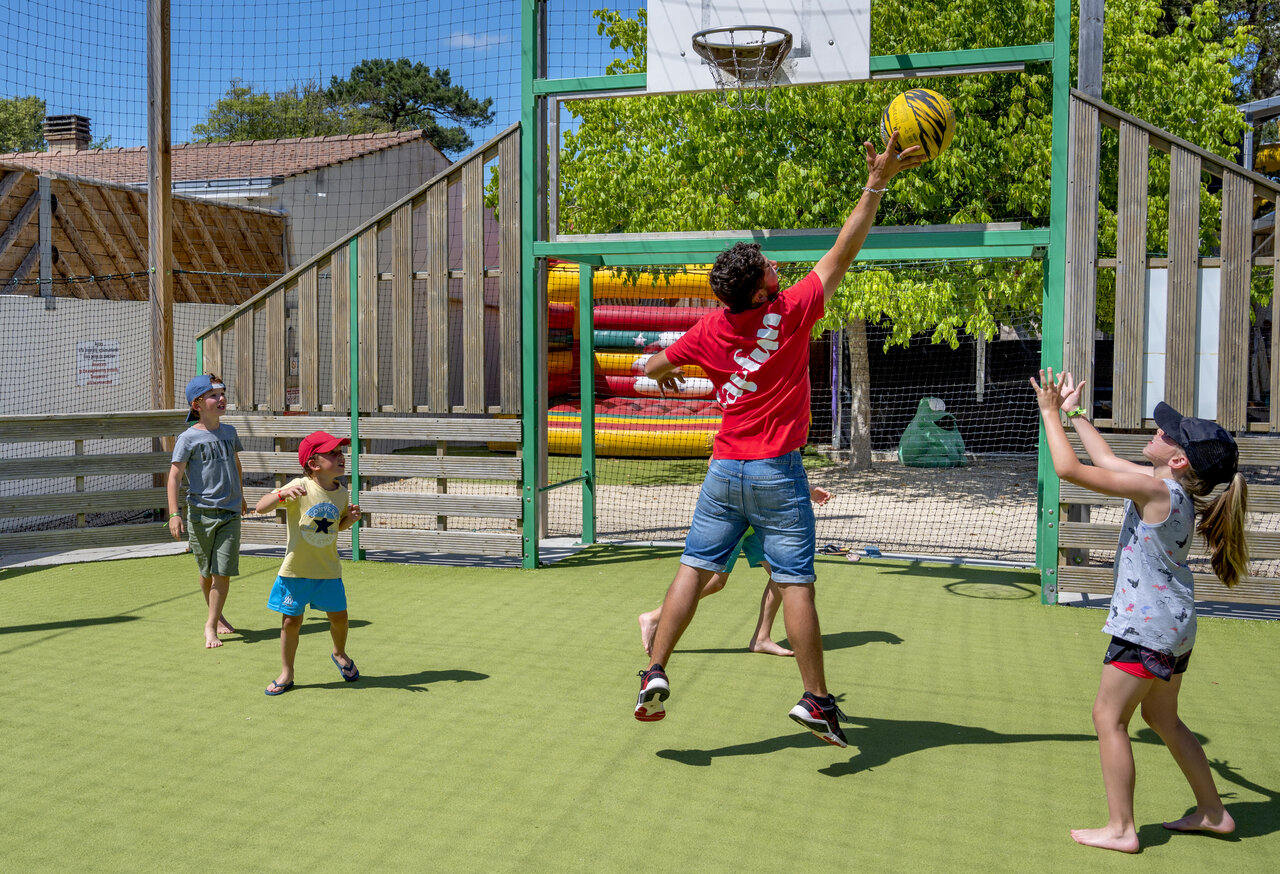 Animator en kinderen spelen basketbal op multisportterrein CAPFUN Ecureuils JARD SUR MER (85).