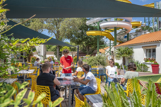 Levendig restaurantterras met gasten en ober op camping CAPFUN Ecureuils in JARD SUR MER (85).
