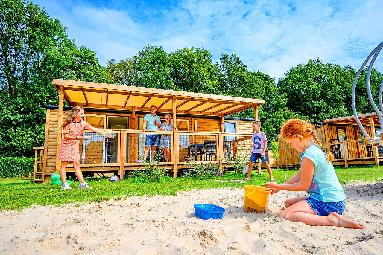 Kinderen spelen badminton en zand op camping CAPFUN Eibernest in Eibergen.