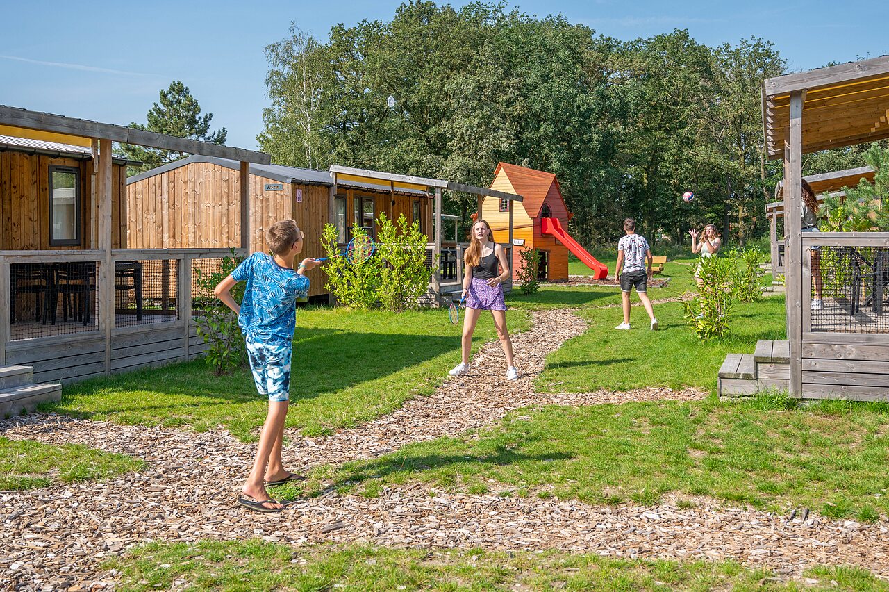 Kinderen spelen badminton bij stacaravans op camping CAPFUN Eibernest in Eibergen.