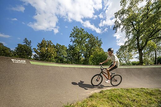 Jonge fietser op moderne pumptrackbaan op camping CAPFUN Eibernest in Eibergen.