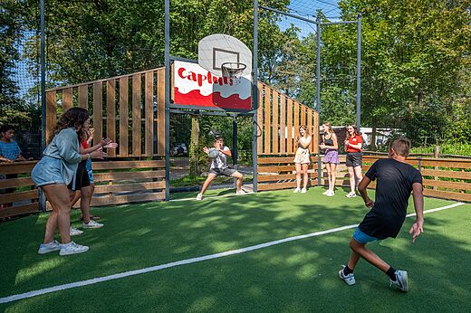 Multisportterrein met jongeren die basketballen op camping CAPFUN Eibernest in Eibergen.