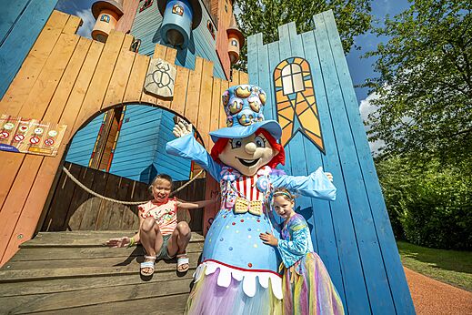 Kinderen en mascotte bij kleurrijke speeltuin op camping CAPFUN Eibernest in Eibergen.