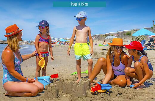 Familie met kinderen spelend op het zandstrand bij camping VAGUES OCEANES Elysée in Le Grau du Roi (30).