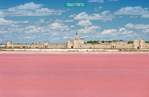 Historische vestingmuren van Aigues-Mortes en roze zoutpannen in de Camargue.