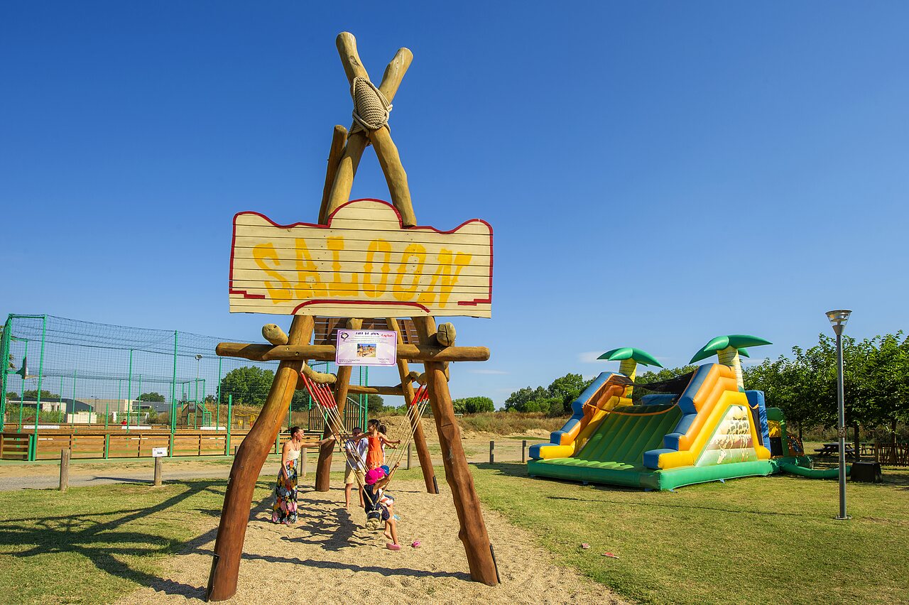 Saloon speeltuin, opblaasbare structuur en kinderen op camping CAPFUN El Moli in Elne (66).