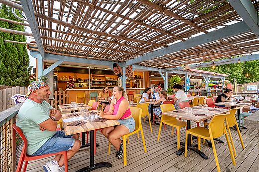 Buitenrestaurant en bar met zittende gasten op camping CAPFUN El Moli in Elne (66).