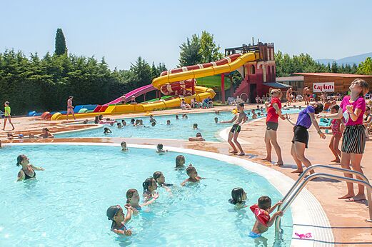 Buitenzwembad met reuzenglijbanen en kinderen op camping CAPFUN El Moli in Elne (66).