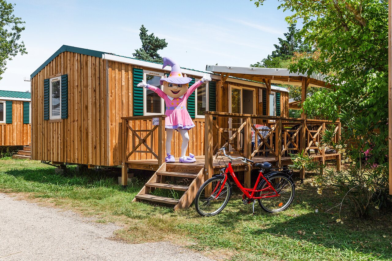 Houten stacaravan met terras en mascotte, op camping CAPFUN Emeraude in Portiragnes (34).