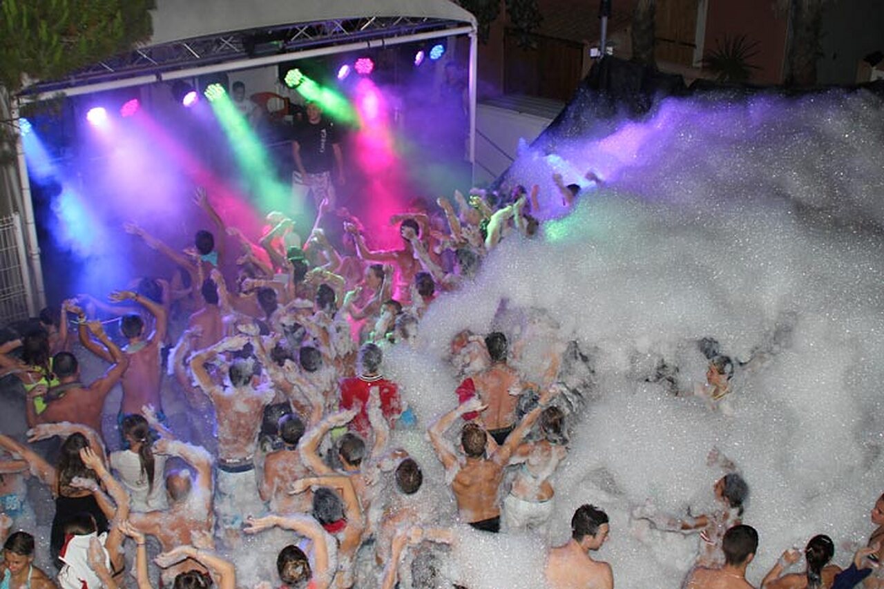 Levendig schuimfeest met kleurrijke lichten op camping CAPFUN Emeraude Portiragnes (34).