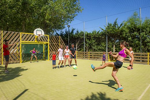 Familie speelt voetbal op multisportveld op camping CAPFUN Emeraude in Portiragnes (34).