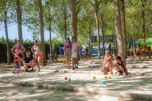 Familie speelt jeu de boules op een schaduwrijk terrein op camping CAPFUN Emeraude in Portiragnes (34).