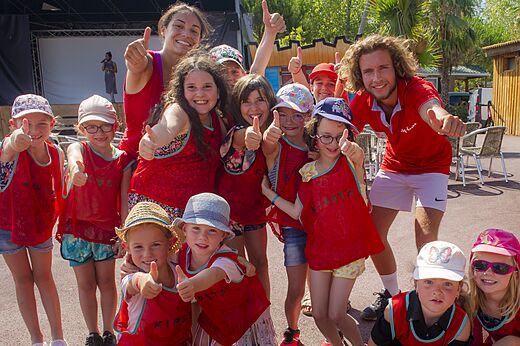 Lachende kinderen en animatoren met duimen omhoog tijdens animatie op camping CAPFUN Emeraude in Portiragnes (34).