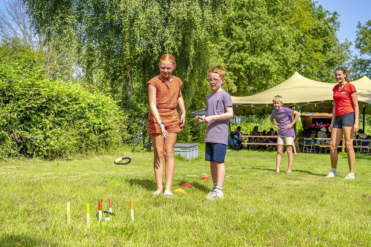 Kinderen spelen ringwerpen op het gras op camping CAPFUN Erkemederstrand in Zeewolde.