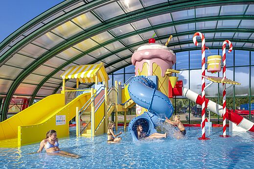 Waterglijbanen en waterspellen in het overdekte zwembad op camping CAPFUN Erkemederstrand in Zeewolde.