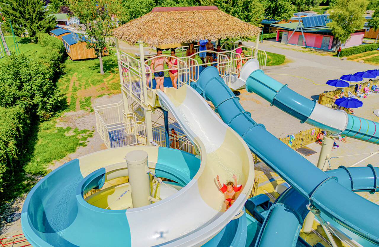 Kind glijdend op reuzenglijbanen bij VAGUES OCEANES Lac d'Erstein (67).