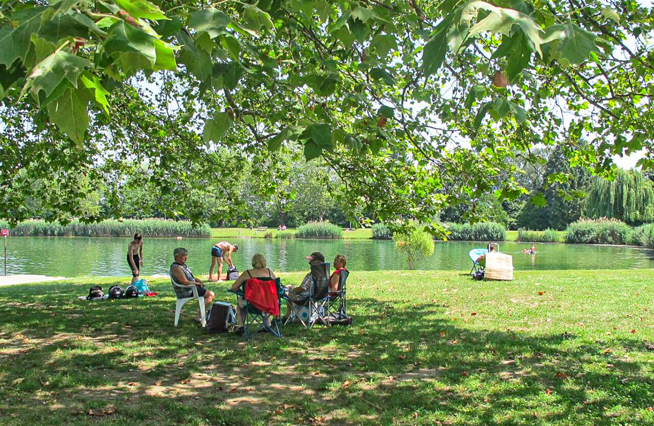 Natuurlijk zwemmeer, schaduwrijke ontspanningsruimte, op camping VAGUES OCEANES Lac d'Erstein in Erstein.