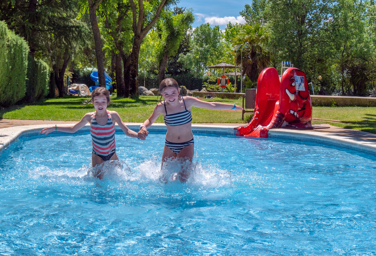 Buitenzwembad met glijbaan en kinderen op camping CAPFUN El Escorial, Madrid.