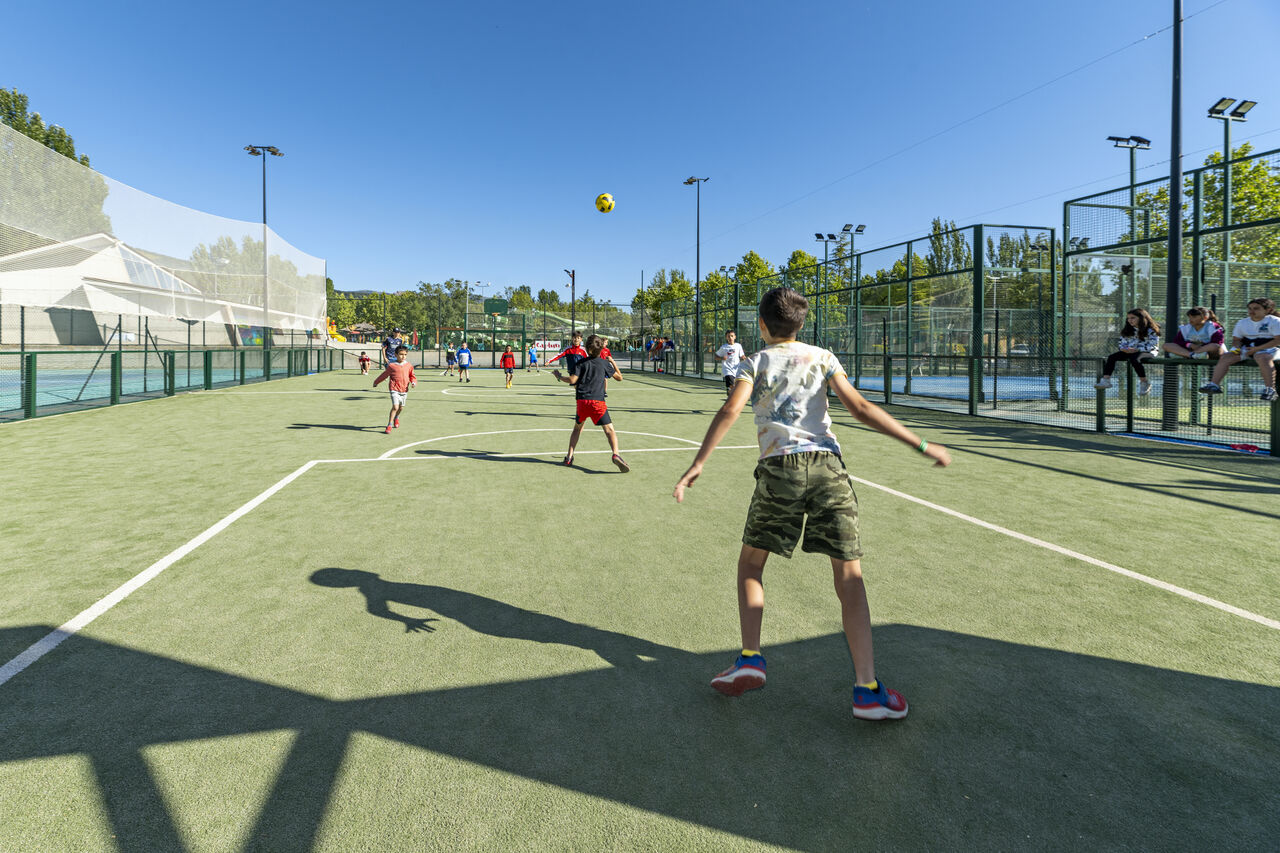Kinderen voetballen op multisportterrein CAPFUN El Escorial, Madrid.