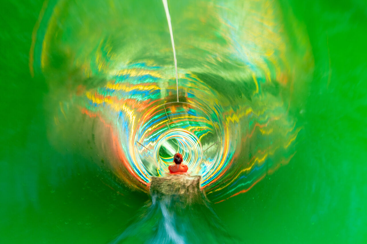 Kleurrijke waterglijbaan, persoon glijdend op camping CAPFUN El Escorial, Madrid.