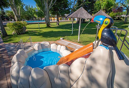 Kinderzwembad met glijbaan en toekan op camping CAPFUN El Escorial, Madrid.