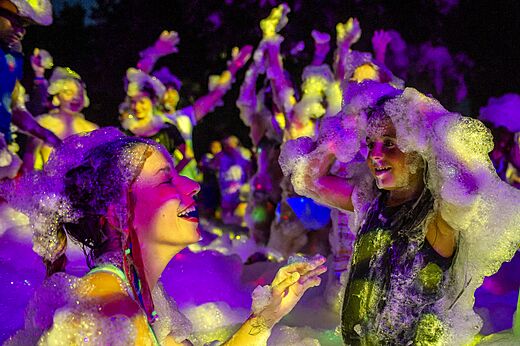 Levendig schuimfeest met kinderen en volwassenen op camping CAPFUN El Escorial in El Escorial, Madrid.