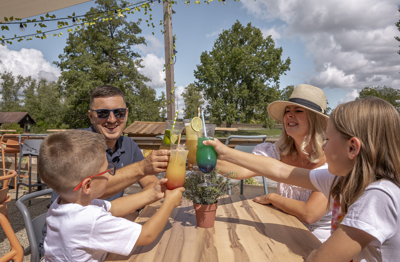 Familie proost met cocktails op bar terras op camping CLICOCHIC in HARPRICH.