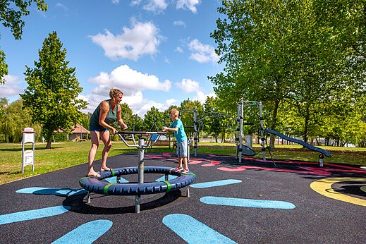 Moderne speeltuin met vrouw en kind op camping CLICOCHIC Etang de la Mutche in HARPRICH (57).