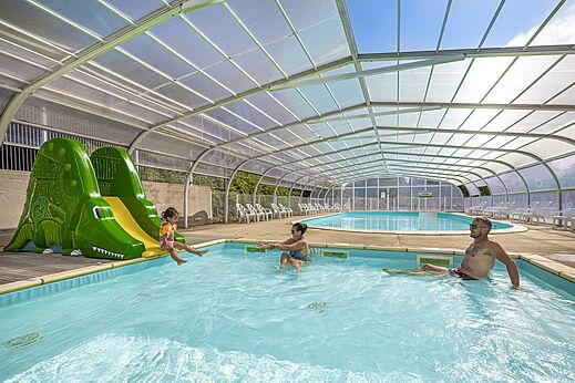Overdekt zwembad, krokodillenglijbaan en gezin op camping CLICOCHIC Etoile de Mer, Asserac.