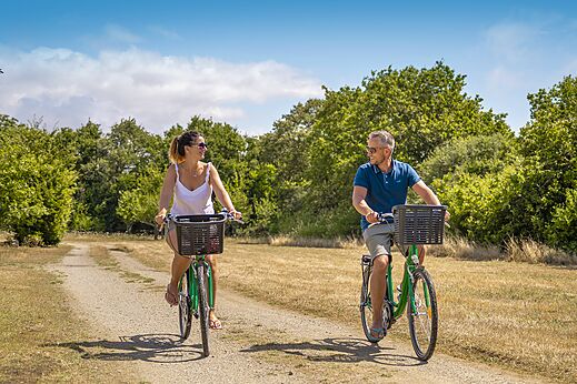 Stel fietst lachend op pad bij camping CLICOCHIC Etoile de Mer in Asserac