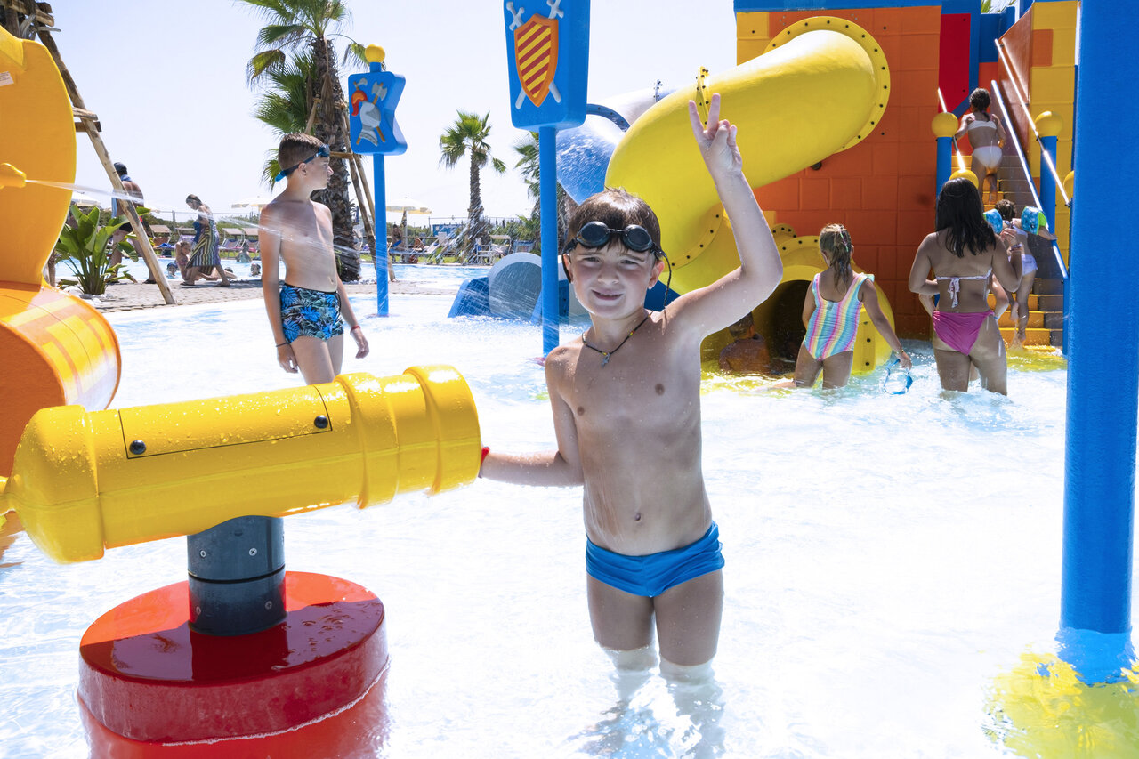 Kinderen spelen in waterpark met glijbanen op camping CAPFUN Europing in Tarquinia.