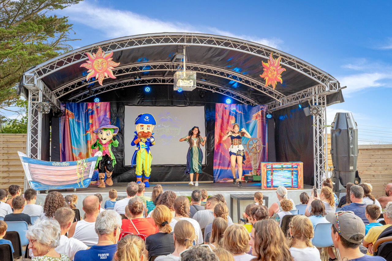Animatieshow met mascottes en artiesten op het podium van camping CAPFUN L'Eve.