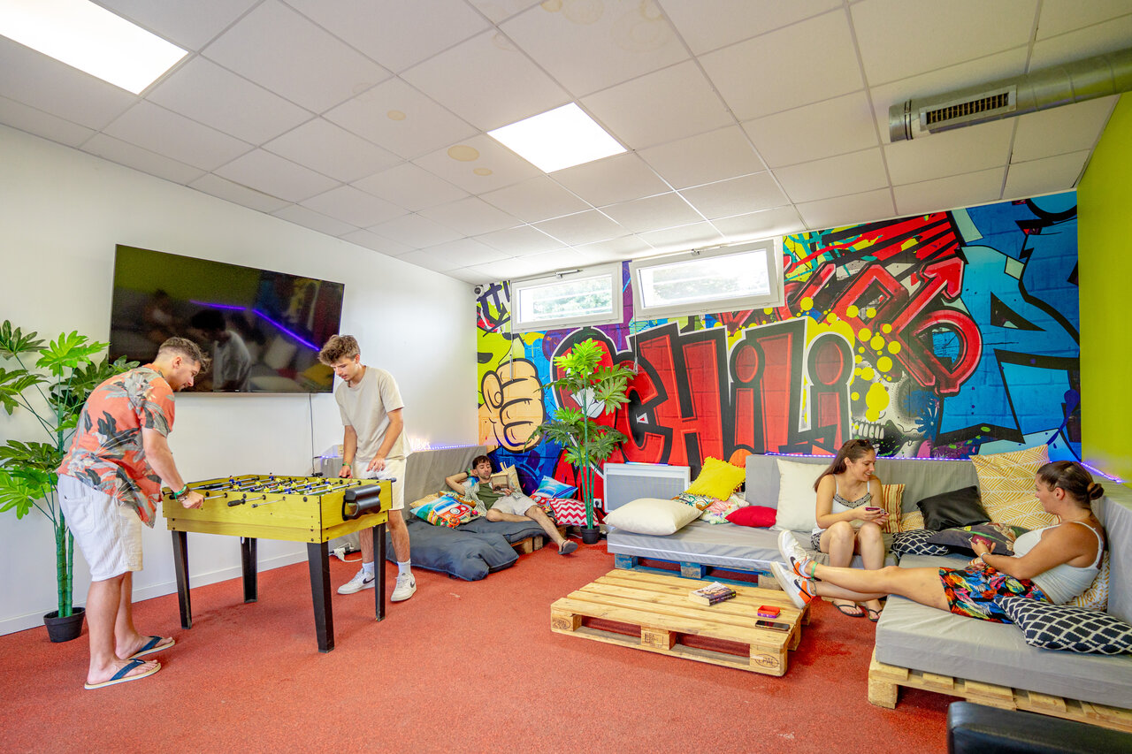 Tafelvoetbal en ontspanningsruimte in de speelzaal van camping CAPFUN L'Eve.