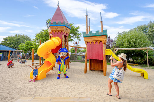 Speeltuin met glijbanen, houten structuren en zand op camping CAPFUN L'Eve in Saint-Marc-sur-Mer (44).