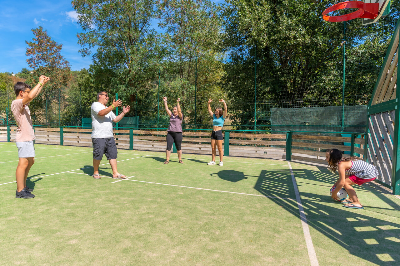 Multisportterrein met familie die basketbal speelt op camping CLICOCHIC Eyrieux.
