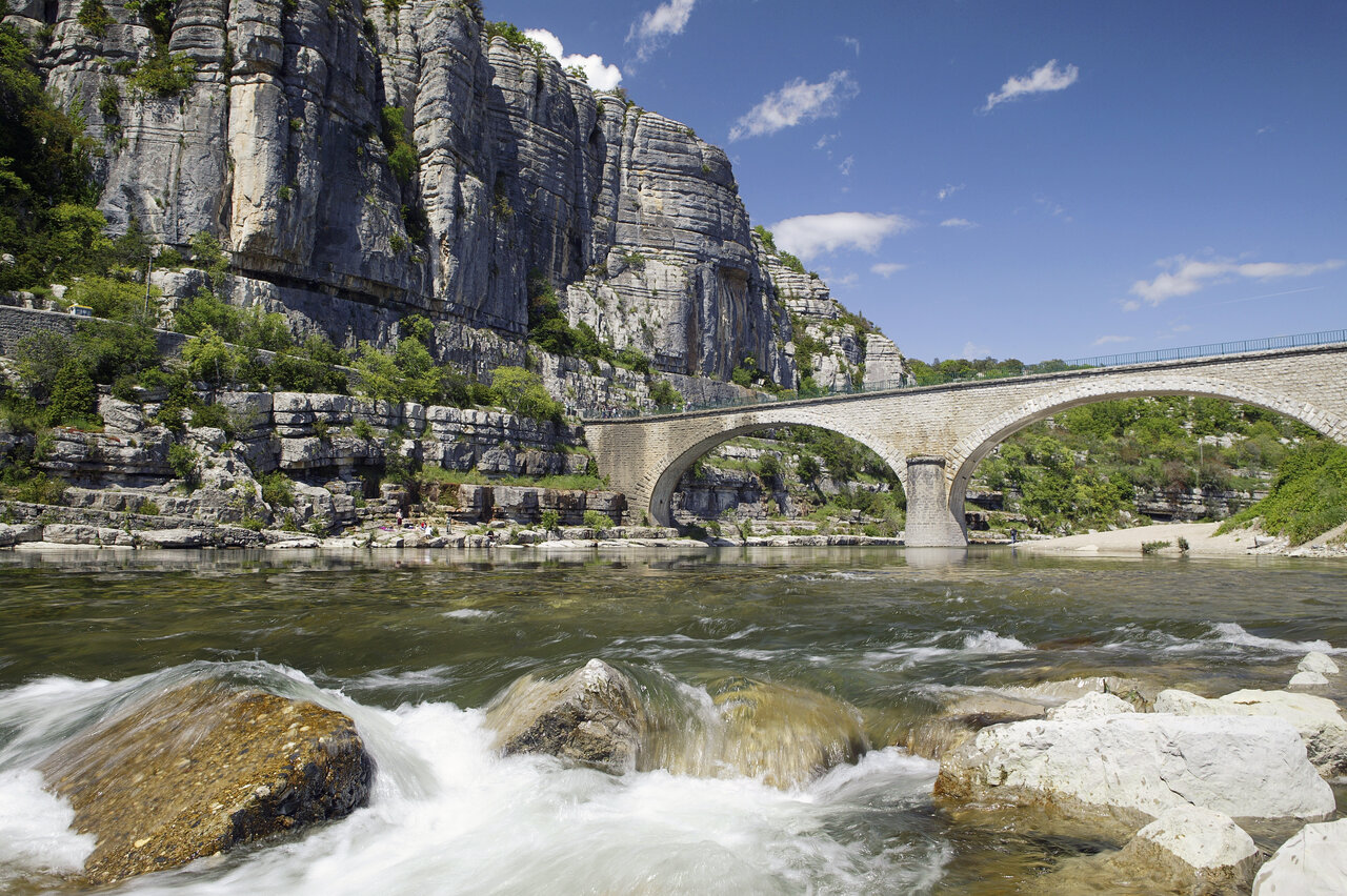 Rivier, rotsachtige kliffen en oude brug op camping CLICOCHIC Eyrieux in Les OLLIERES-SUR-EYRIEUX.