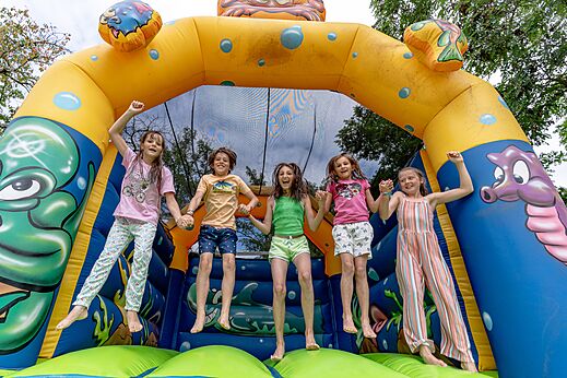Springkasteel en blije kinderen op camping CLICOCHIC Eyrieux in Les OLLIERES-SUR-EYRIEUX.