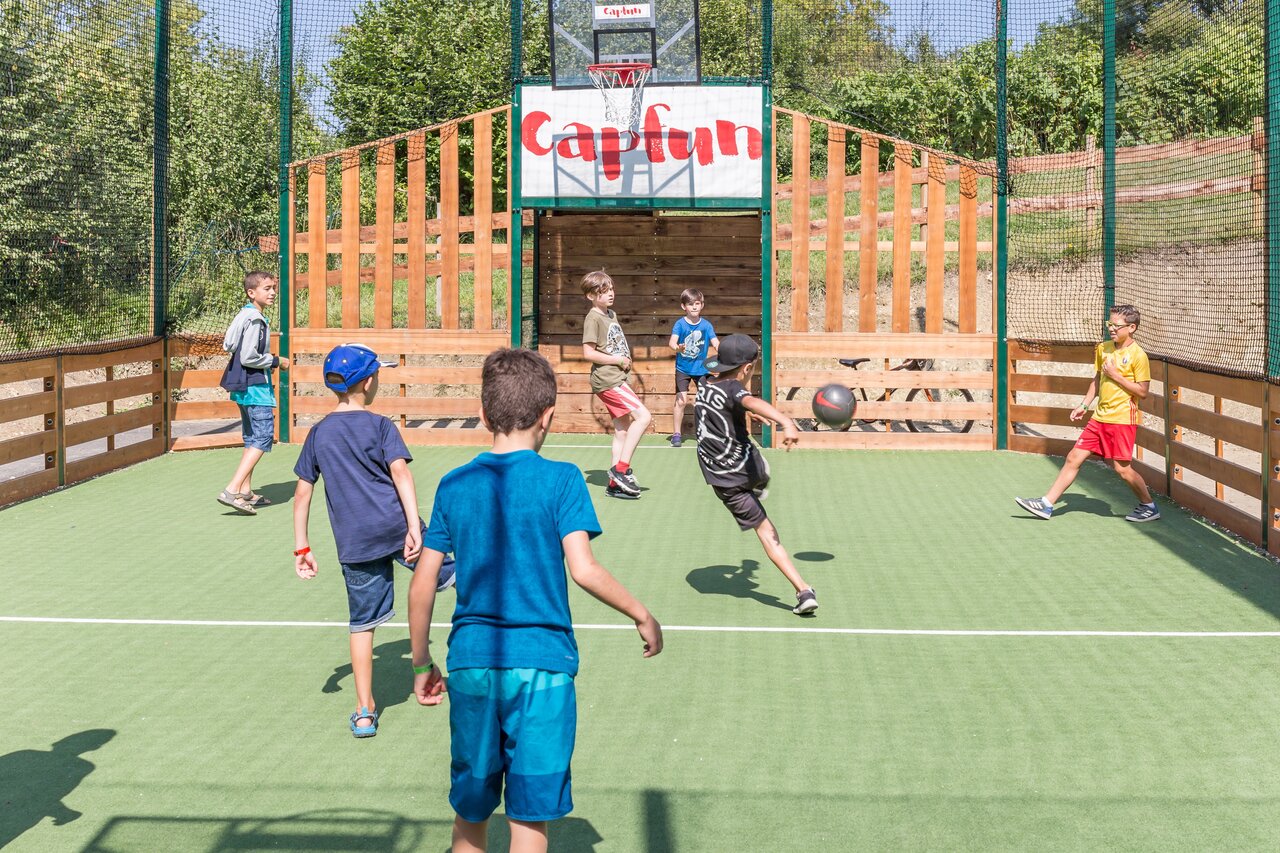 Kinderen voetballen op multisportterrein op camping CAPFUN Falaises in Gonneville sur Mer (14).