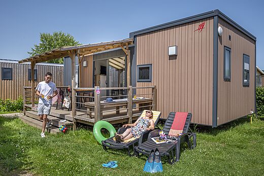 Modern stacaravan met terras, vakantiegangers bij CAPFUN Falaises, Gonneville sur Mer.